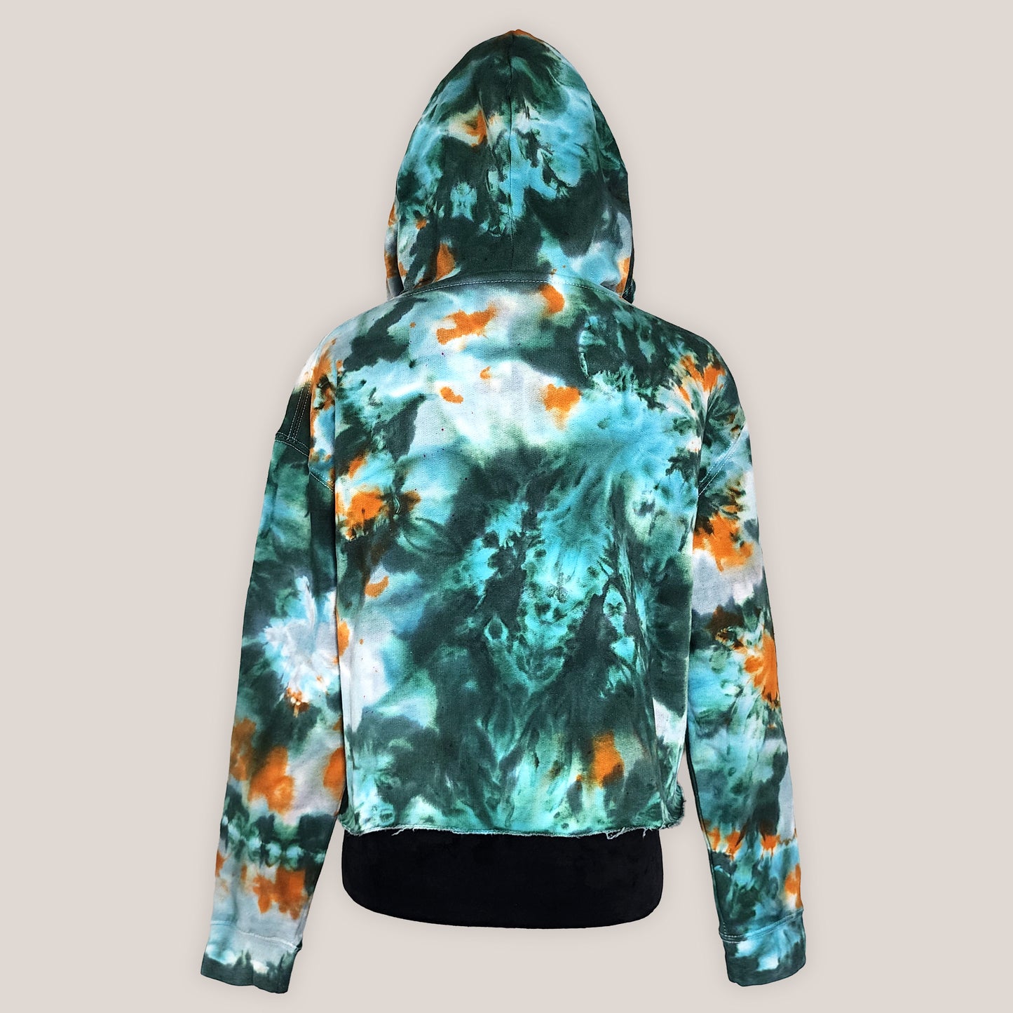 Tie-dye hoodie with green, orange, and white pattern on a beige background