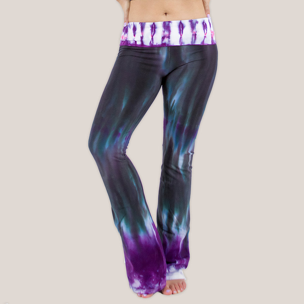 Woman wearing a pair of Akasha Sun sustainable cotton tie dye yoga pants in the colors black and purple.