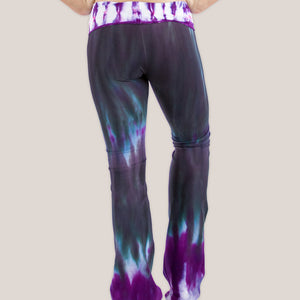 Woman wearing a pair of Akasha Sun sustainable cotton tie dye yoga pants in the colors black and purple.