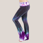 Woman wearing a pair of Akasha Sun sustainable cotton tie dye yoga pants in the colors black and purple.