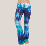 Woman wearing the Galapagos Islands tie dye yoga pants that features hand-dyed hues of navy blue, teal, and aqua.  These pants include a fold over waistband that is also comfortable as maternity wear.