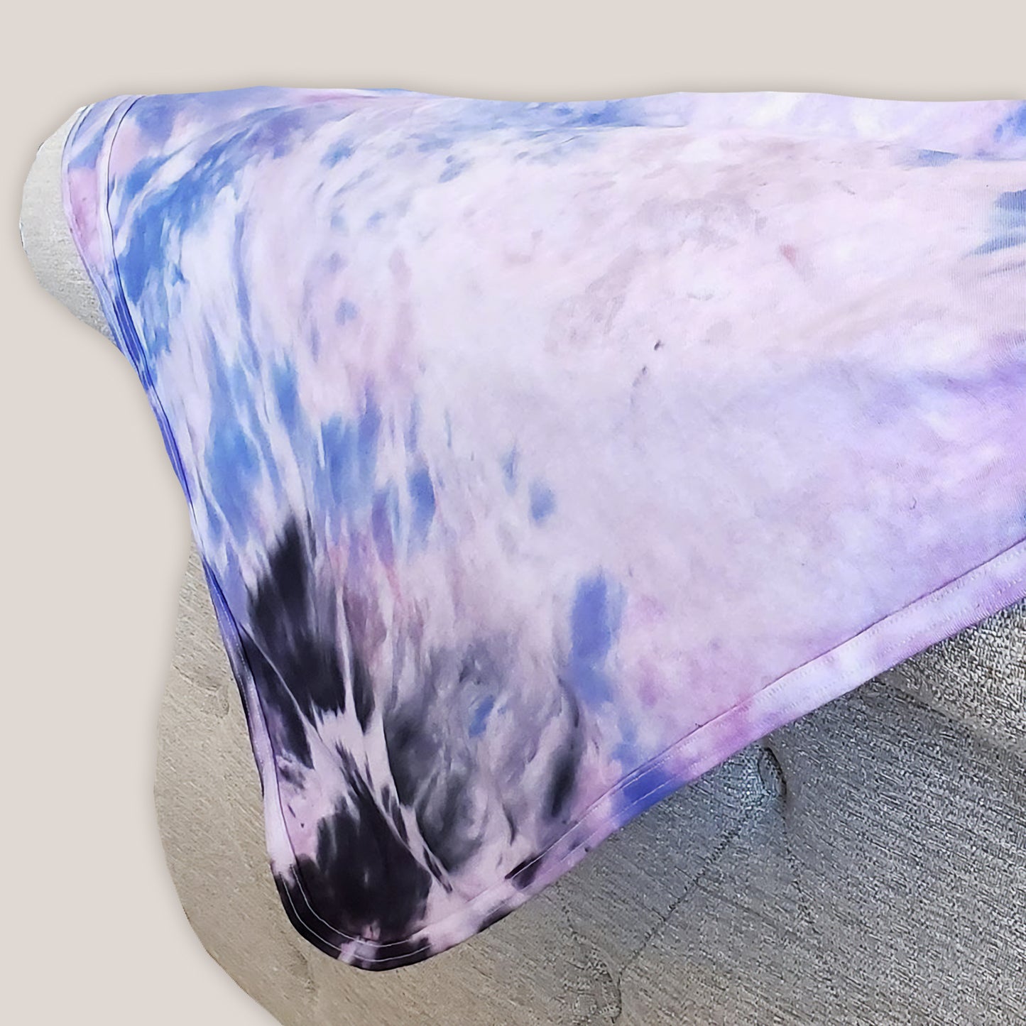 A periwinkle and black tie dye organic baby blanket with rounded corners.