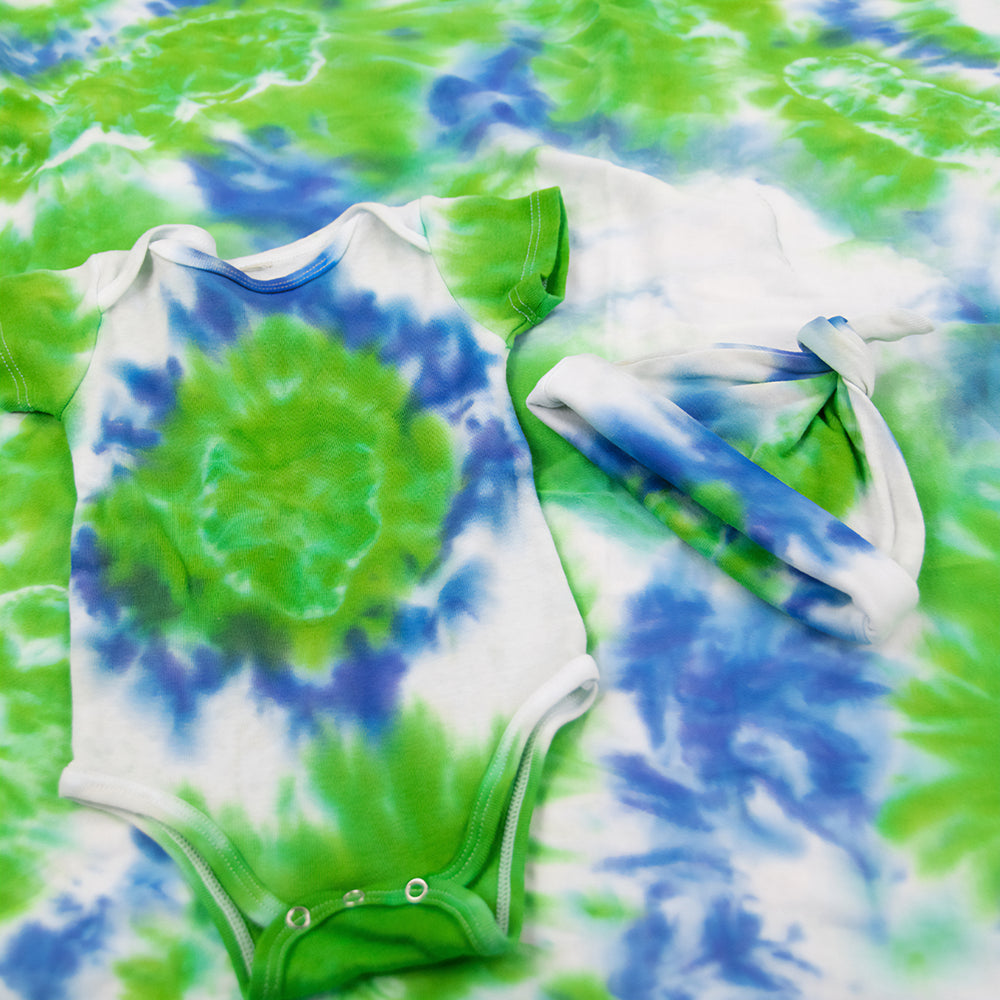 Blue, green, and white tie dye organic baby set that includes a baby blanket, bodysuit, and baby hat.