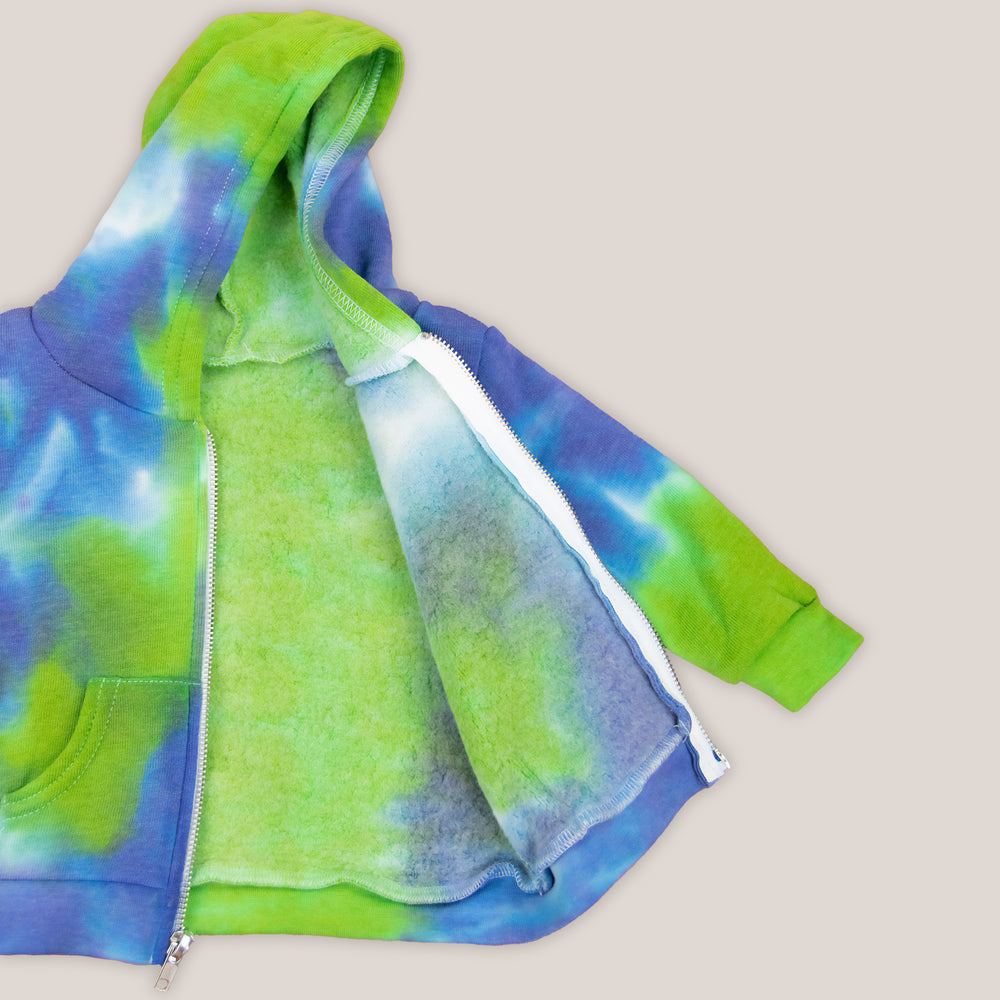 Blue and green tie dye baby zip up featuring a hood, fleece lining, and pockets.