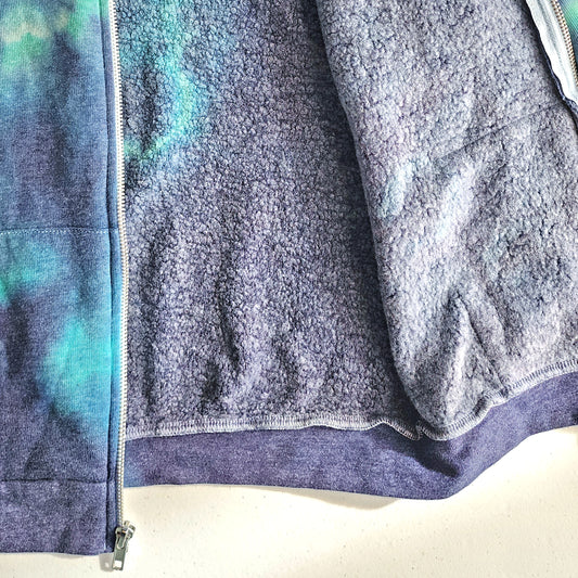 Close-up of a fleece jacket with tie dye colors on a white background