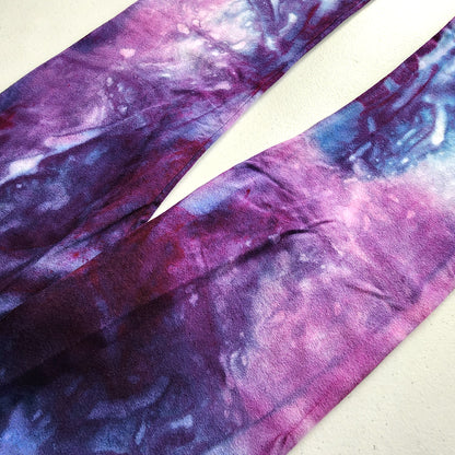 Purple tie-dye pants up close on a white background