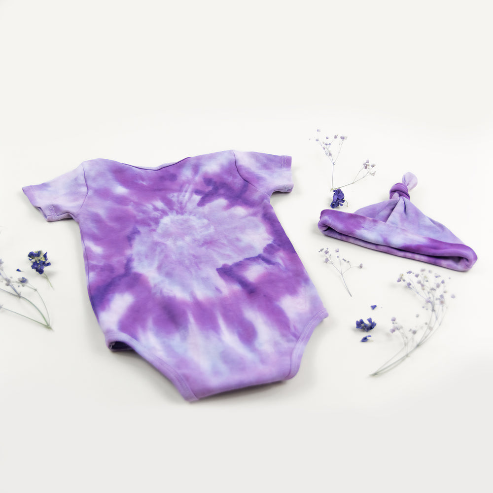 Purple organic cotton tie dye baby bodysuit and hat by Akasha Sun.