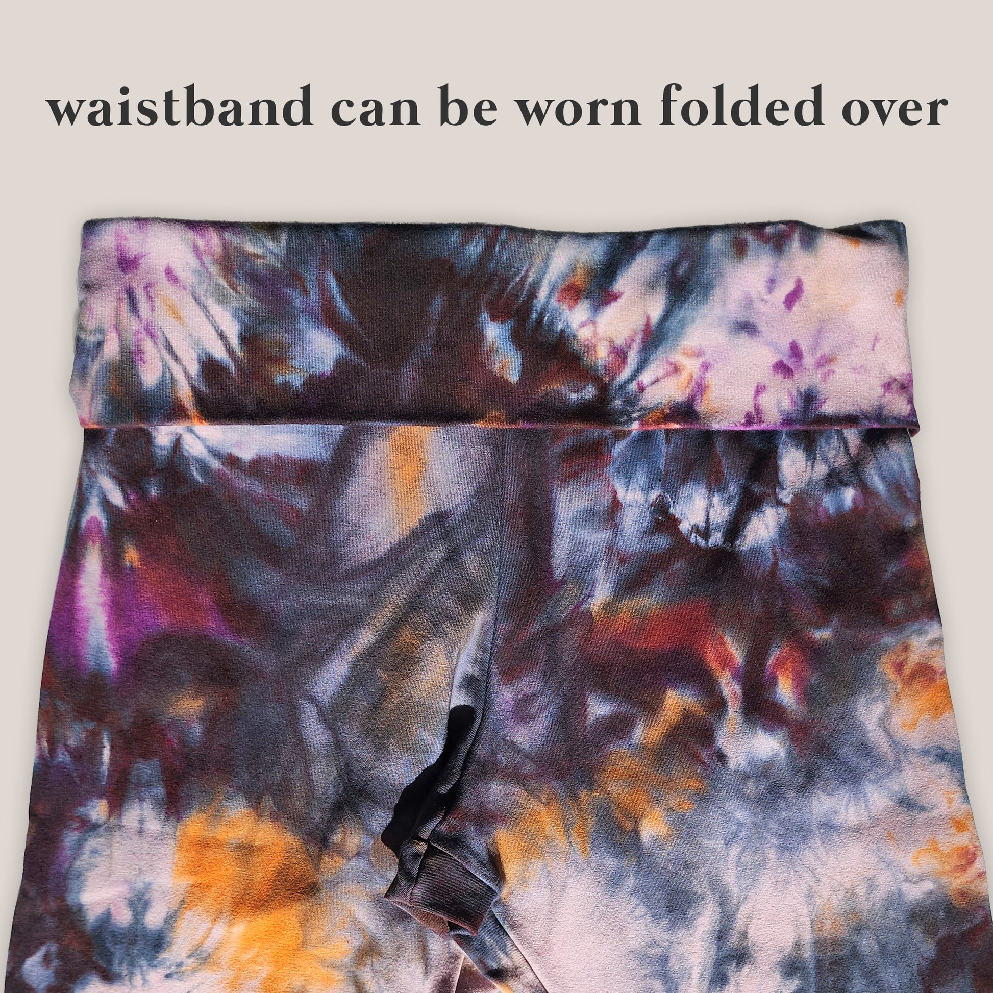 Tie-dye waistband with text indicating it can be worn folded over on a light gray background