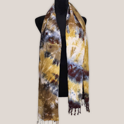 Tie-dye scarf with brown, yellow, and black pattern on a mannequin against a white background