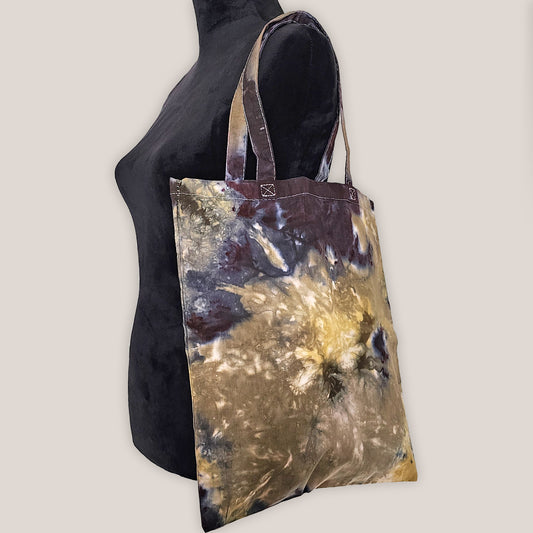 Tote bag with abstract design on a mannequin against a plain background