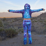 Woman wearing a pair of tie dye yoga pants and hoodie crop top by Akasha Sun