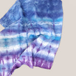 A dog modeling our tie dye bandana in blue and purple by Akasha Sun