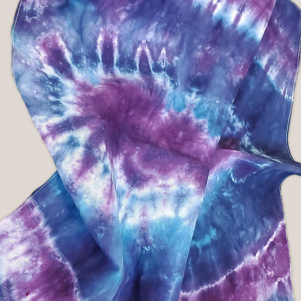 A dog modeling our tie dye bandana in blue and purple by Akasha Sun