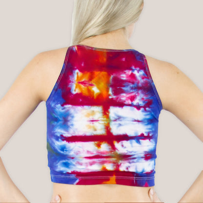 Woman wearing a blue, red, and orange rainbow tie dye crop top.