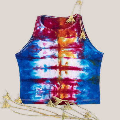 Woman wearing a blue, red, and orange rainbow tie dye crop top.