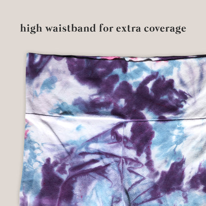 Tie-dye patterned yoga pants with text 'high waistband for extra coverage' on a beige background
