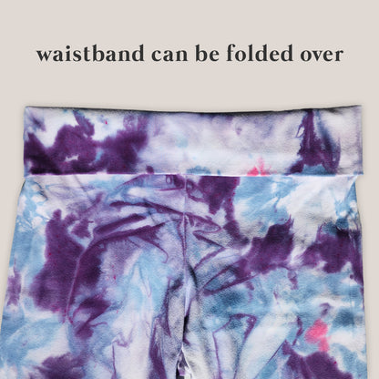 Tie-dye yoga pants with a folded waistband on a light background