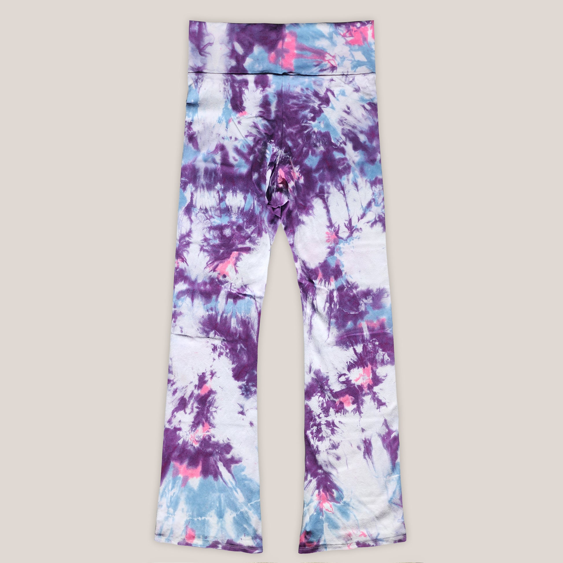 Tie-dye leggings with purple, blue, and pink patterns on a beige background