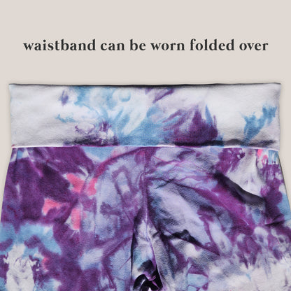 Tie-dye patterned pants with folded over waistband on a beige background