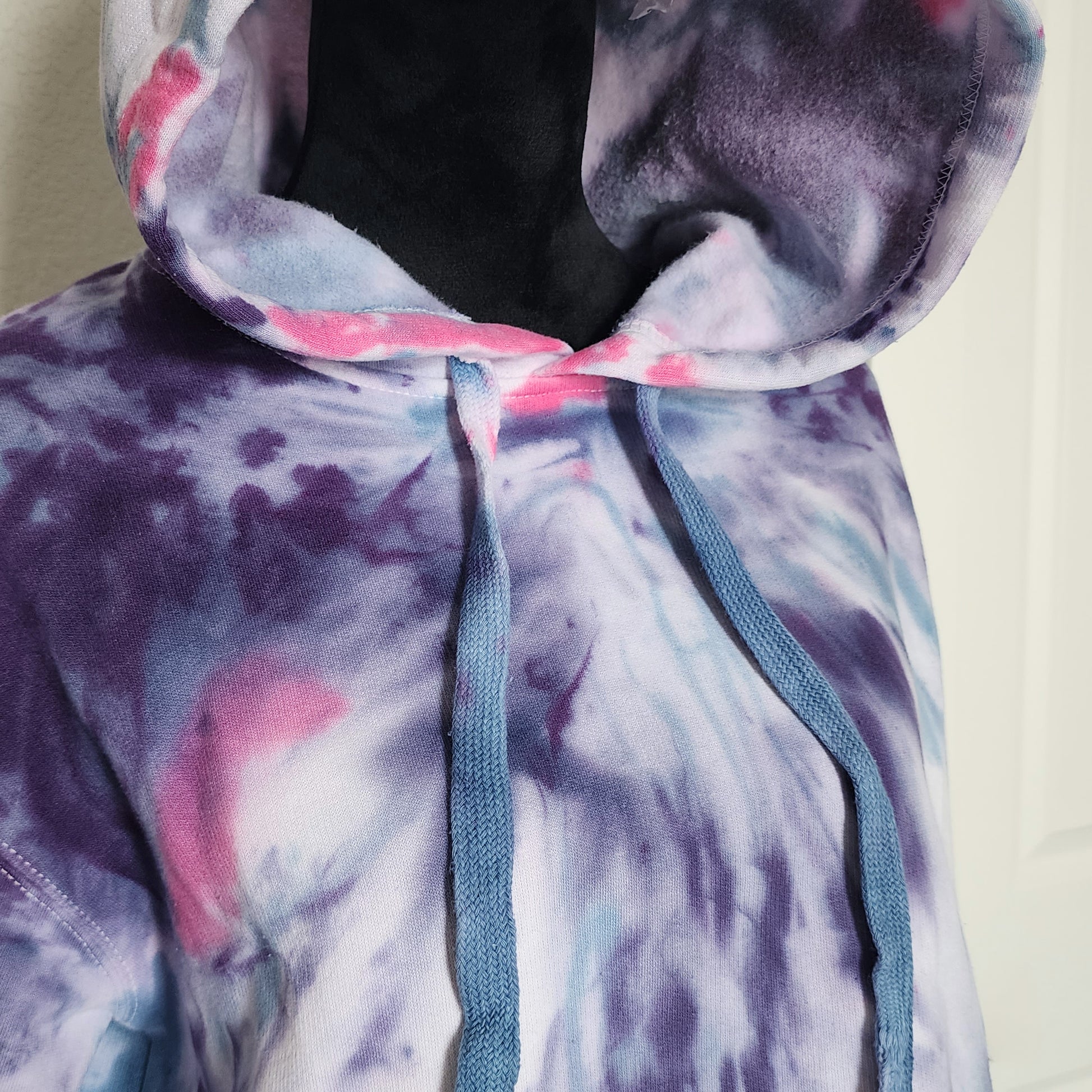 Hoodie with pink and purple tie-dye pattern on a plain background
