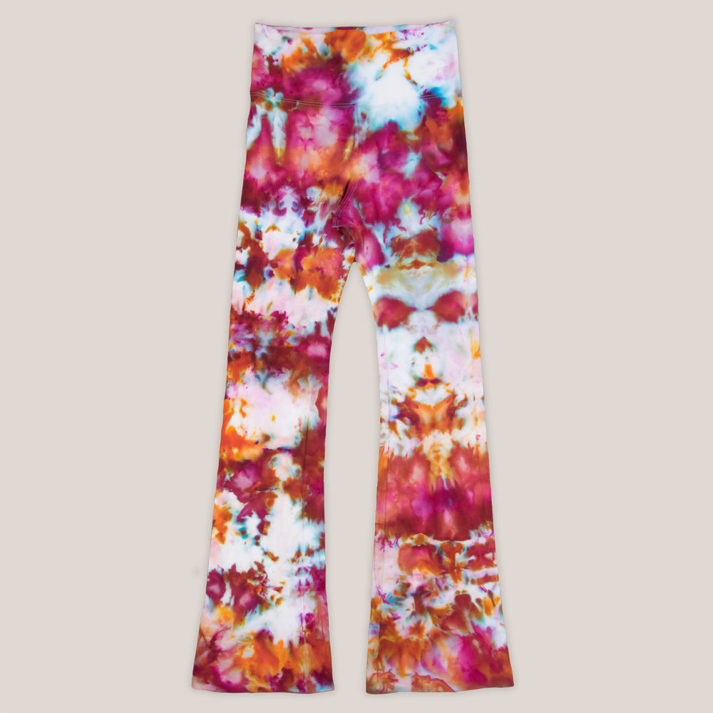 Pink and orange ice dye yoga pants with a wide waistband and flare bottoms.