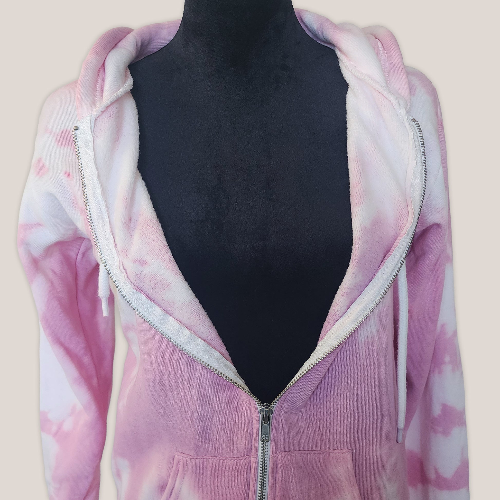 Pink tie-dye hoodie on a mannequin against a beige background