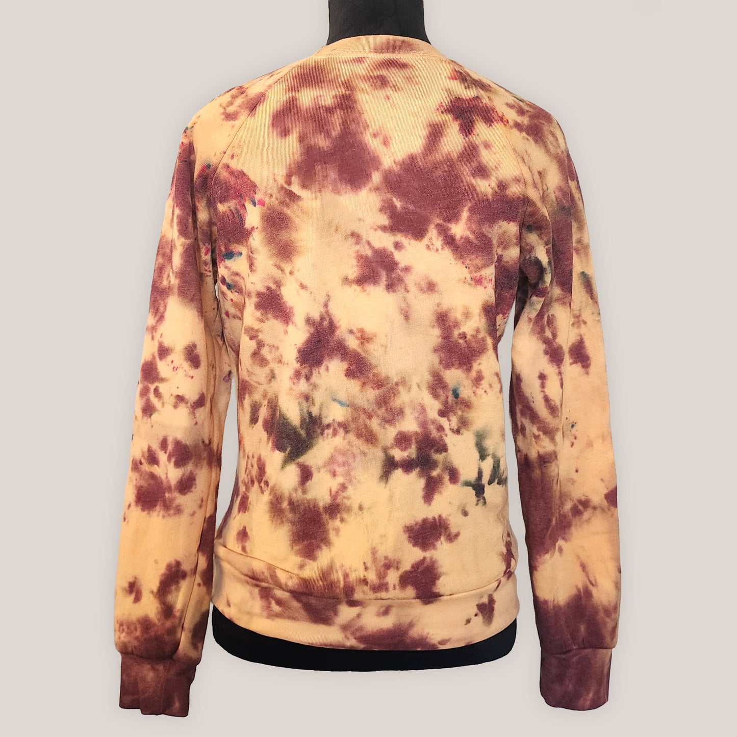 Tie-dye sweatshirt with an orange marbled pattern on a plain background