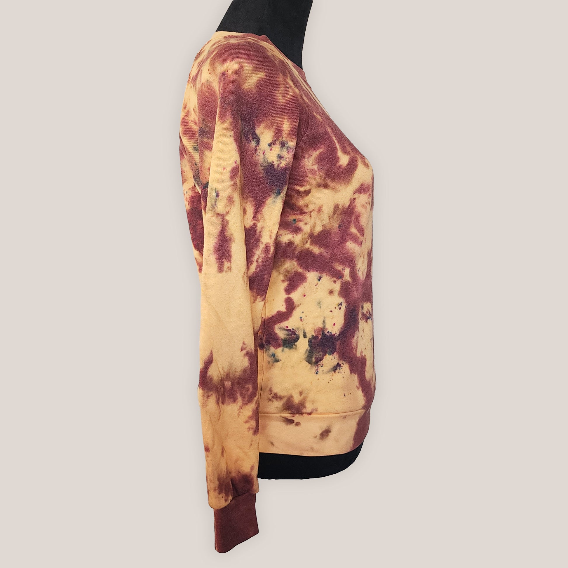 Tie-dye sweatshirt with brown and orange pattern on a plain background