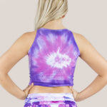 Woman wearing the Saint-Tropez tie dye crop top that features purple and pink hues.