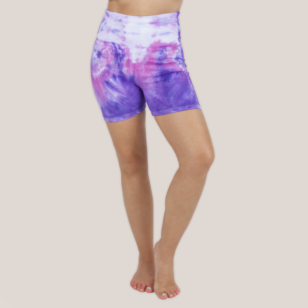 Woman wearing the Saint-Tropez fold over shorts that feature the color purple, pink, and white.