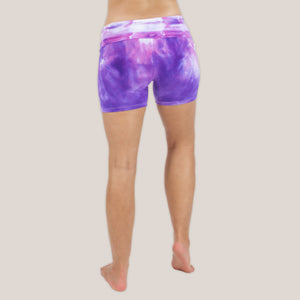 Woman wearing the Saint-Tropez fold over shorts that feature the color purple, pink, and white.