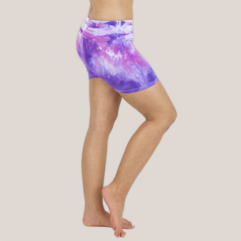 Woman wearing the Saint-Tropez fold over shorts that feature the color purple, pink, and white.