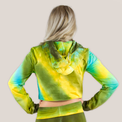 Woman wearing a tie dye hoodie crop top in green, yellow, and teal by Akasha Sun.