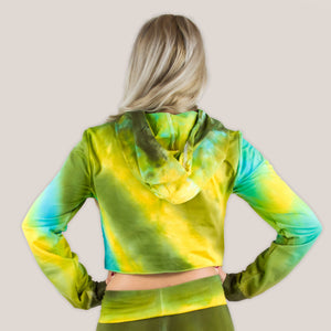 Woman wearing a tie dye hoodie crop top in green, yellow, and teal by Akasha Sun.