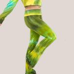 Woman wearing a pair of green tie dye yoga pants with a fold over waistband by Akasha Sun.