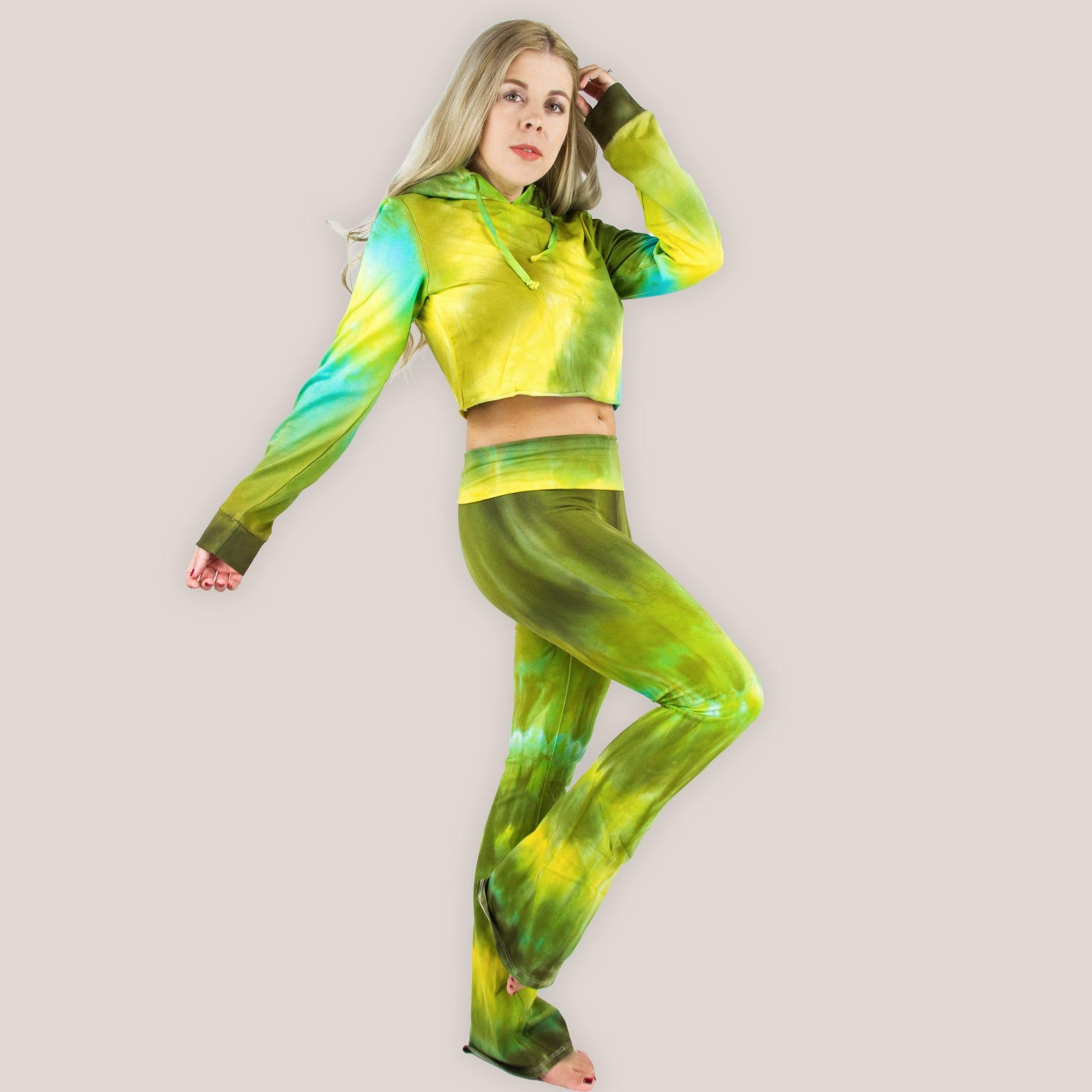 Person wearing a green and yellow tie-dye outfit on a plain background