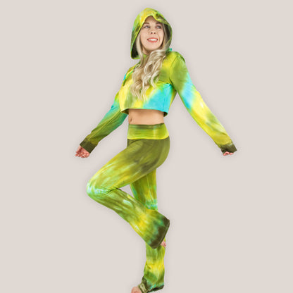 Woman wearing a green and yellow tie-dye outfit on a plain background