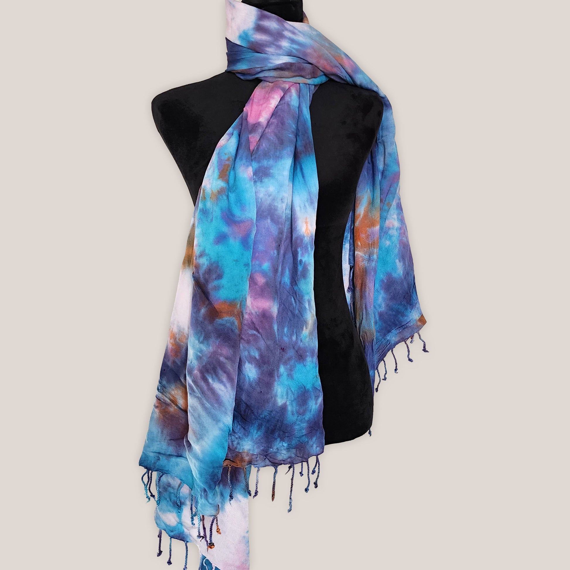 Colorful tie-dye scarf on a mannequin against a plain background