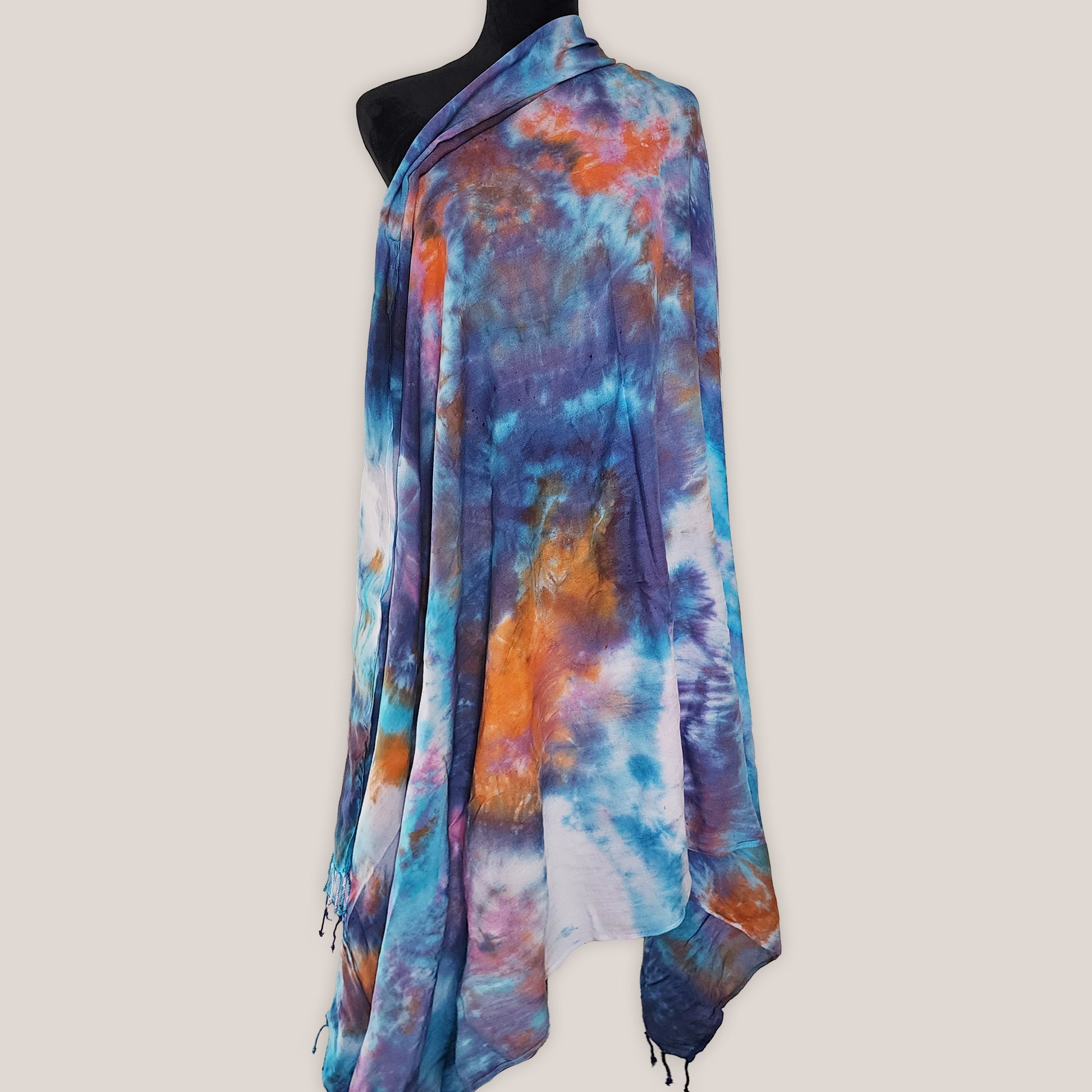 Colorful tie-dye scarf on a mannequin against a plain background