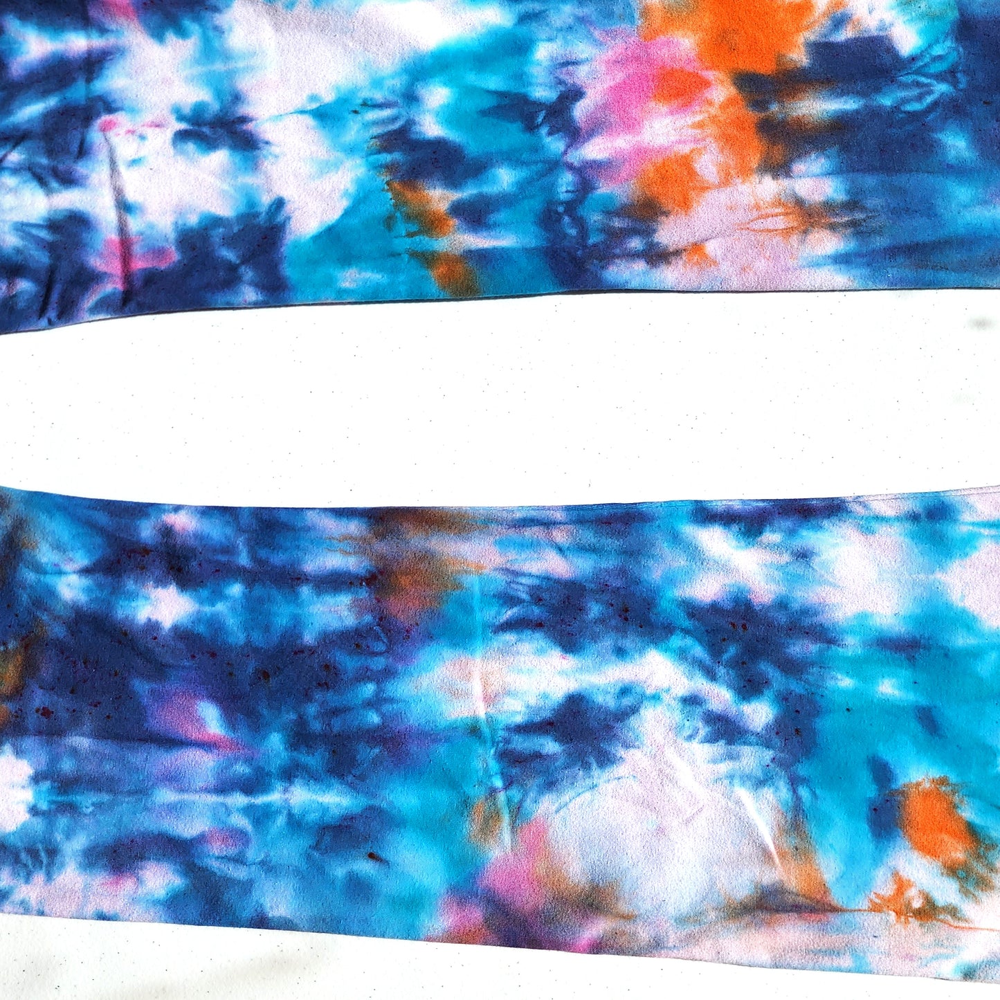 Tie-dye pattern with blue, pink, and orange colors on a white background