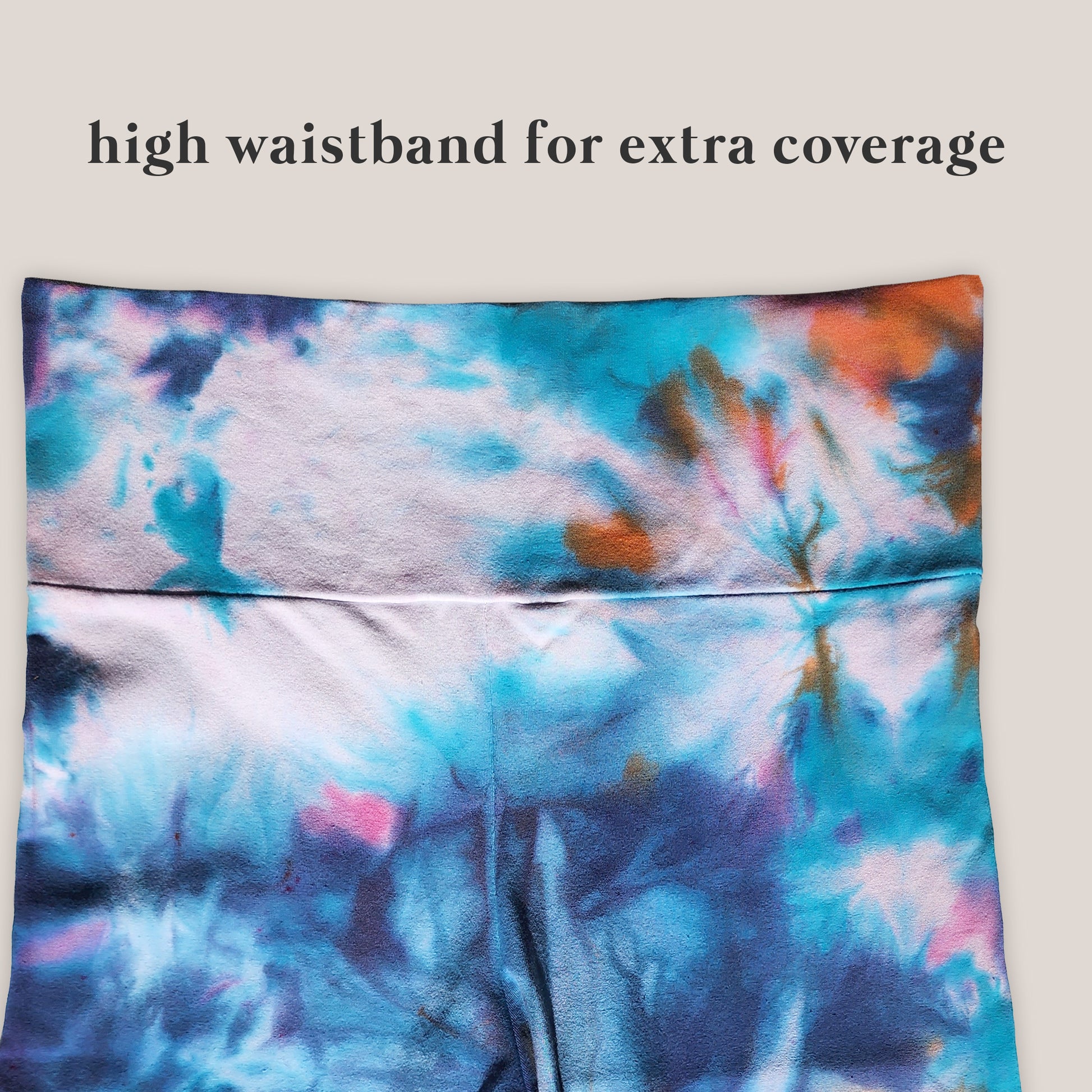 Tie-dye patterned high-waisted garment on a plain background with text 'high waistband for extra coverage'.
