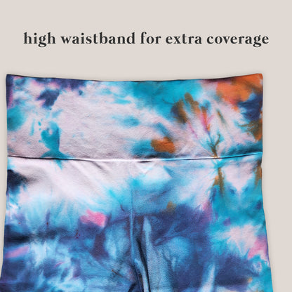Tie-dye patterned high-waisted garment on a plain background with text 'high waistband for extra coverage'.