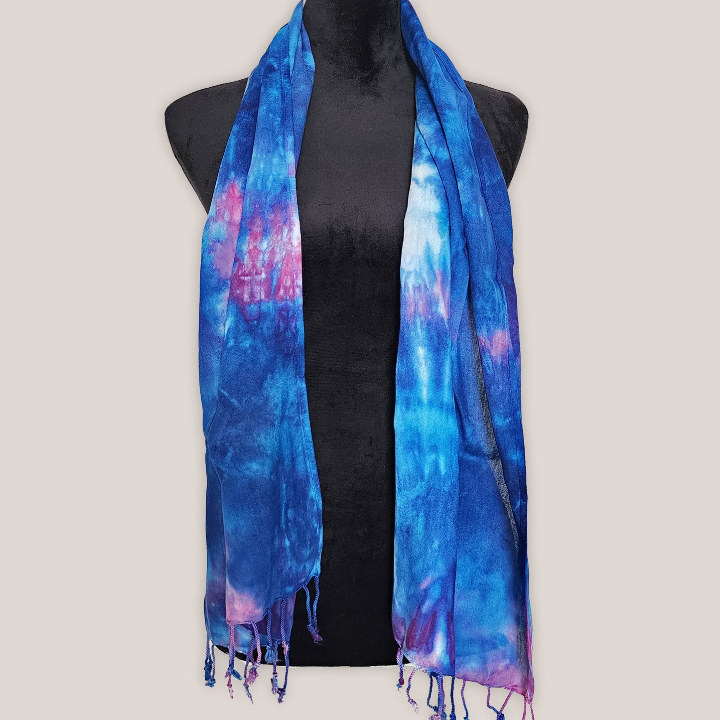 Blue and pink tie-dye scarf on a black mannequin against a beige background