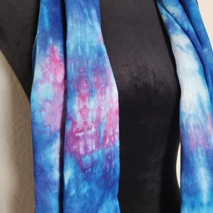 Blue and pink tie-dye scarf draped over a black mannequin.