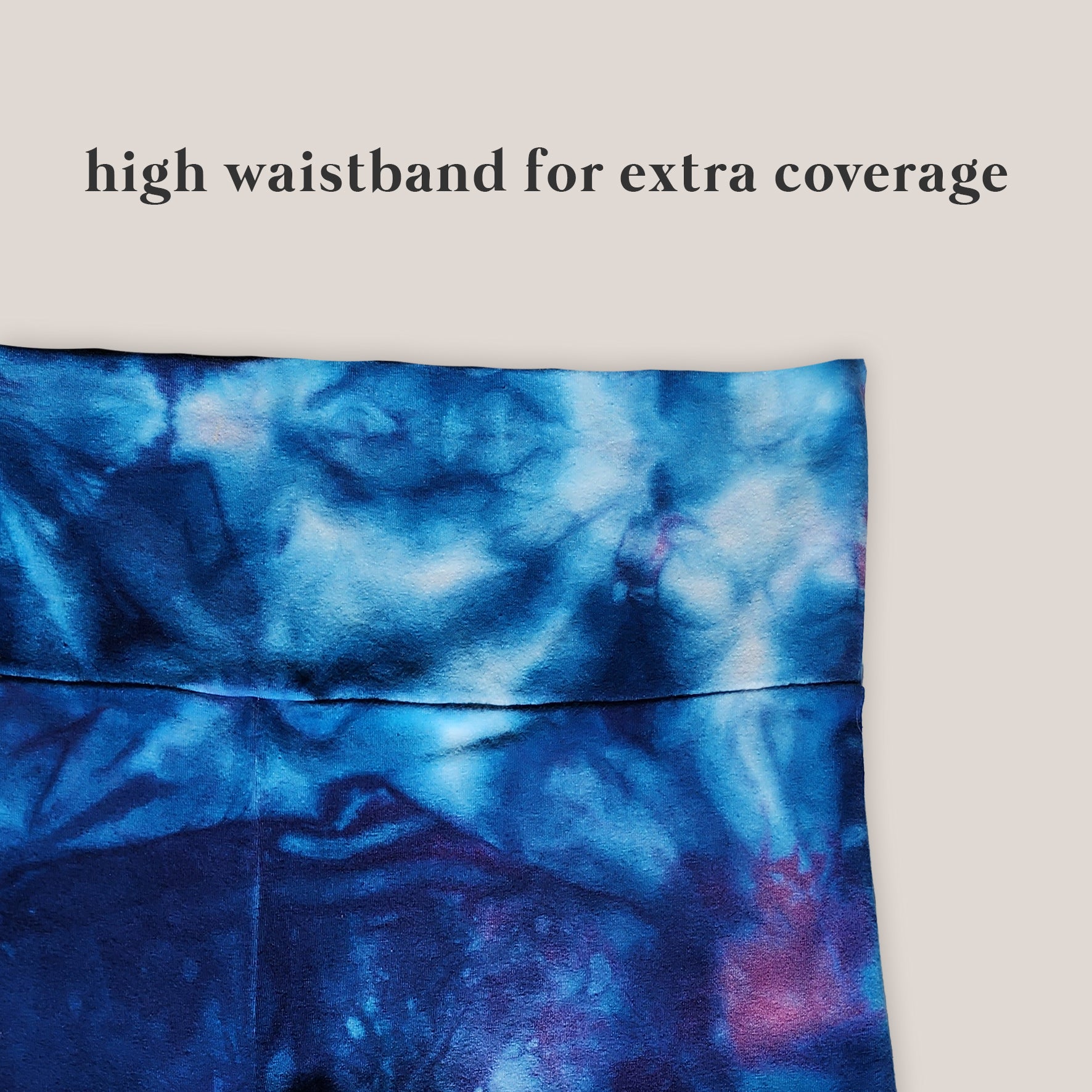 Blue tie-dye pants up close with a high waistband on a beige background
