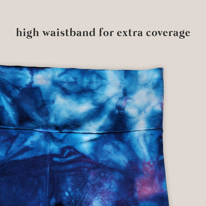 Blue tie-dye pants up close with a high waistband on a beige background