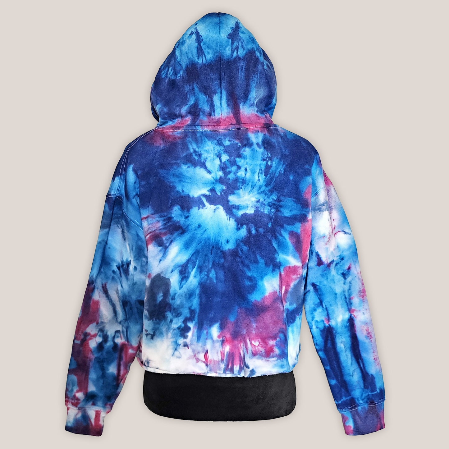 Tie-dye hoodie with blue, pink, and white patterns on a beige background