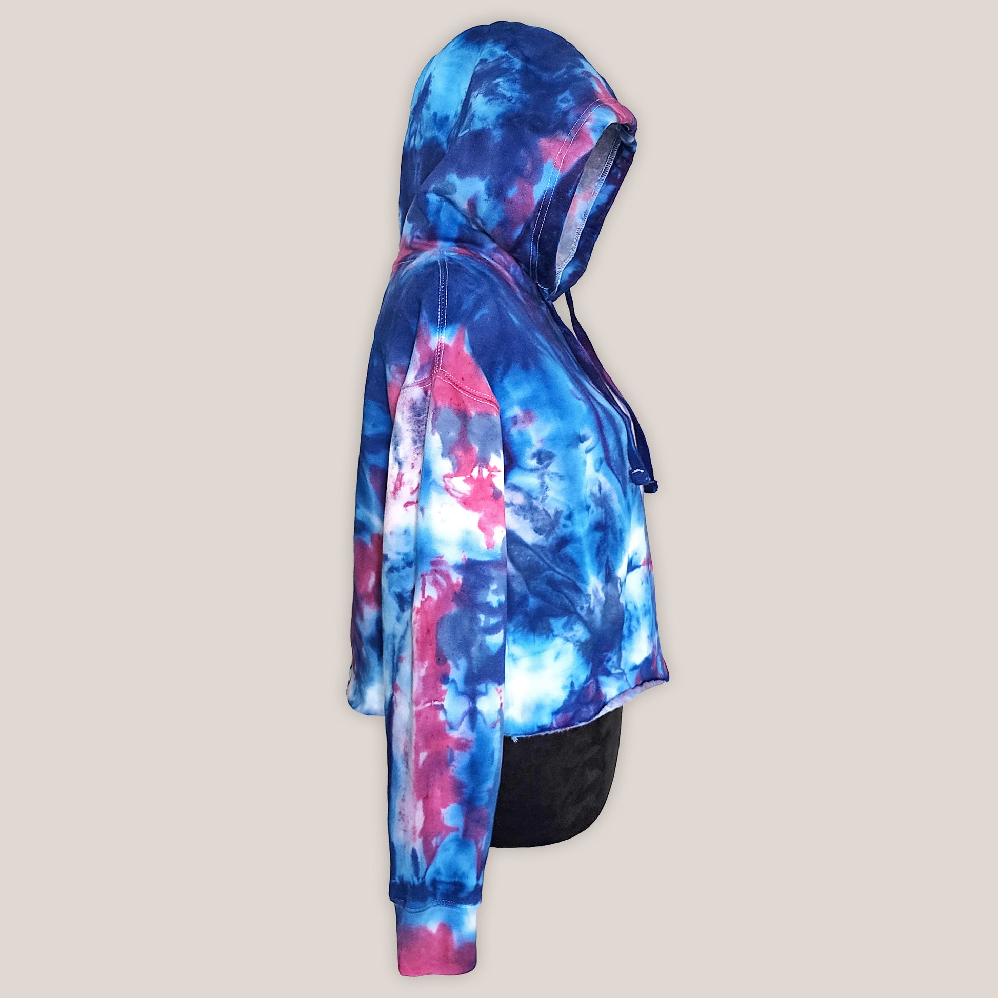 Tie-dye hoodie with blue and pink patterns on a beige background