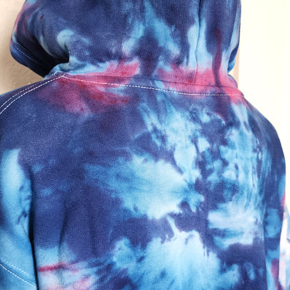Tie-dye hoodie with blue and purple patterns on a plain background