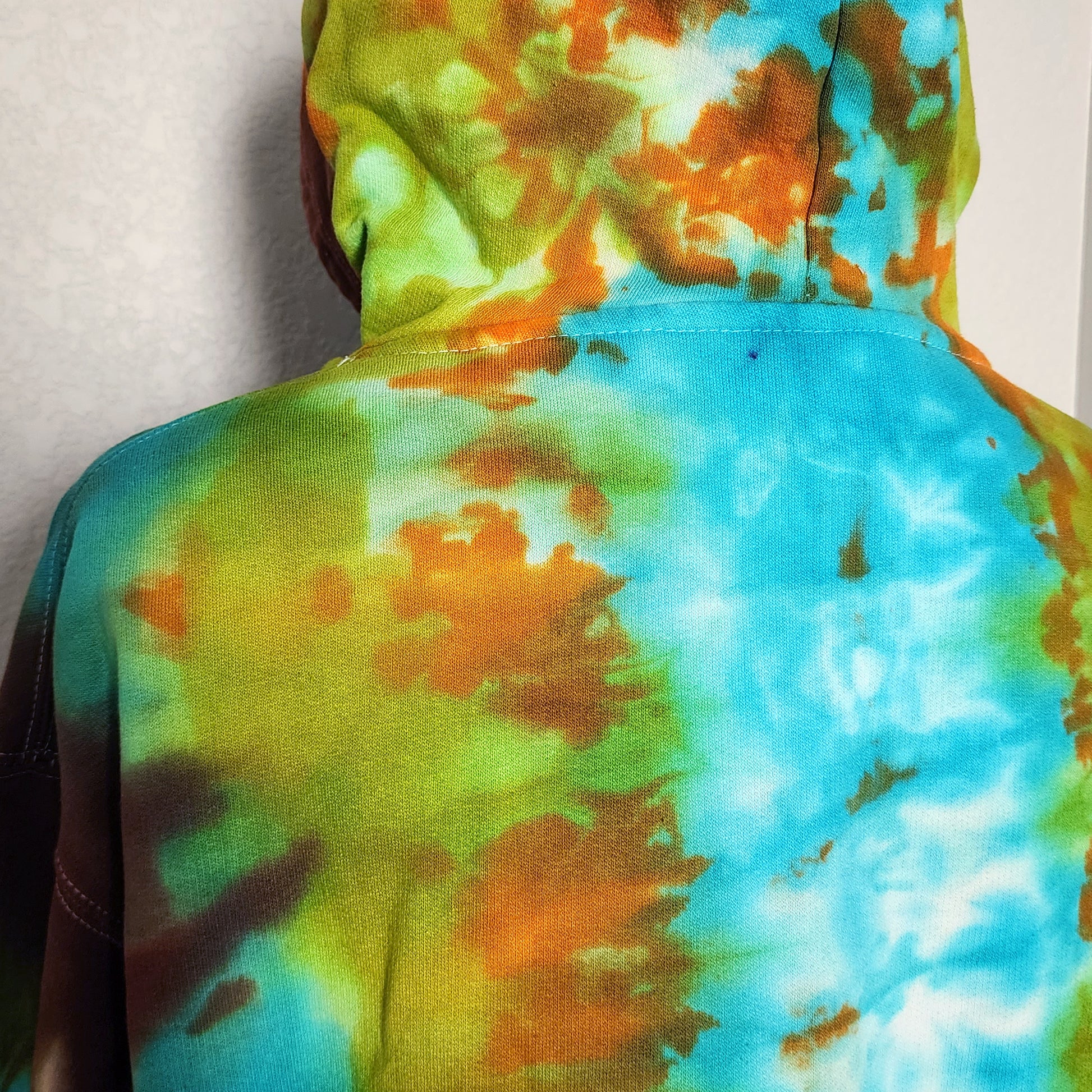 Tie-dye hoodie with a colorful pattern on a plain background